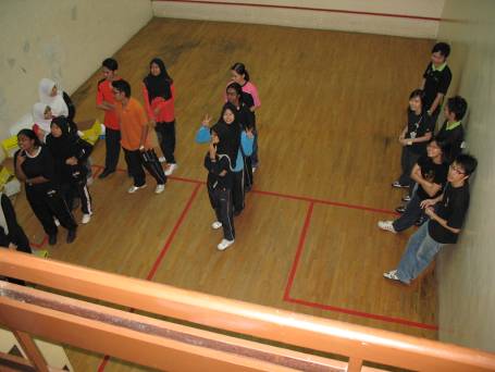 Participants in the squash room listening to instructions